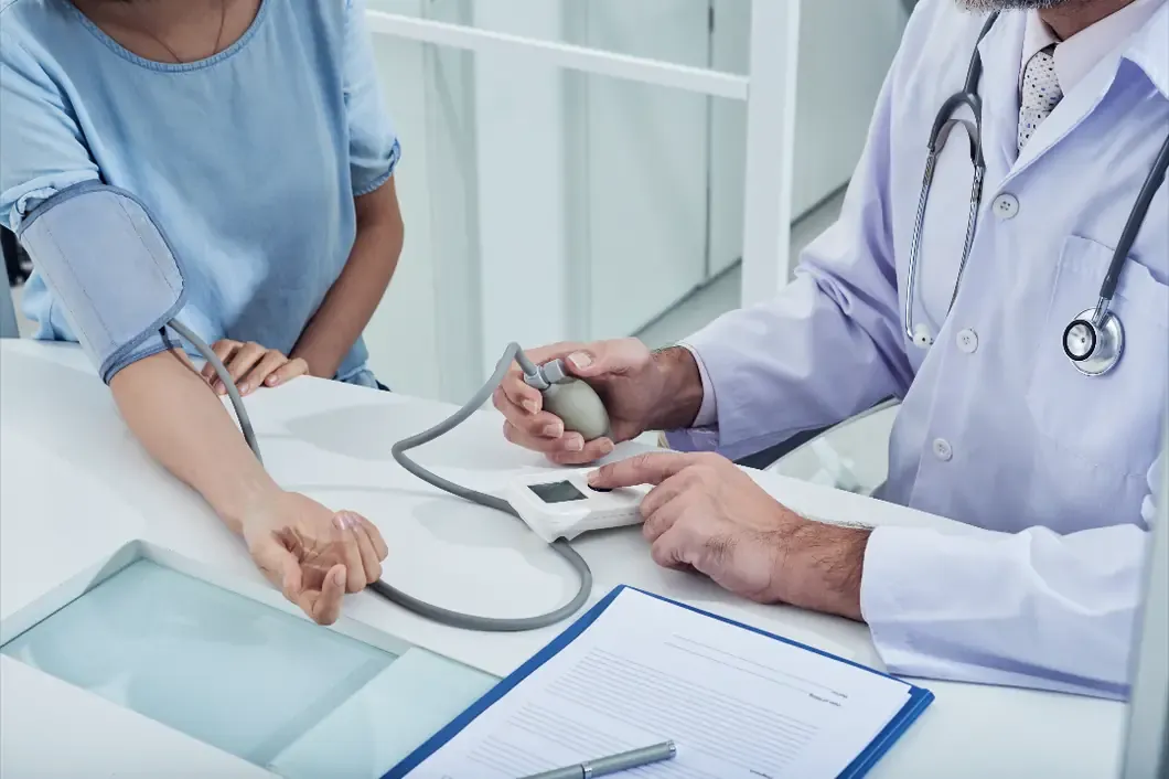 Doctor checking a patient's blood pressure in a clinic