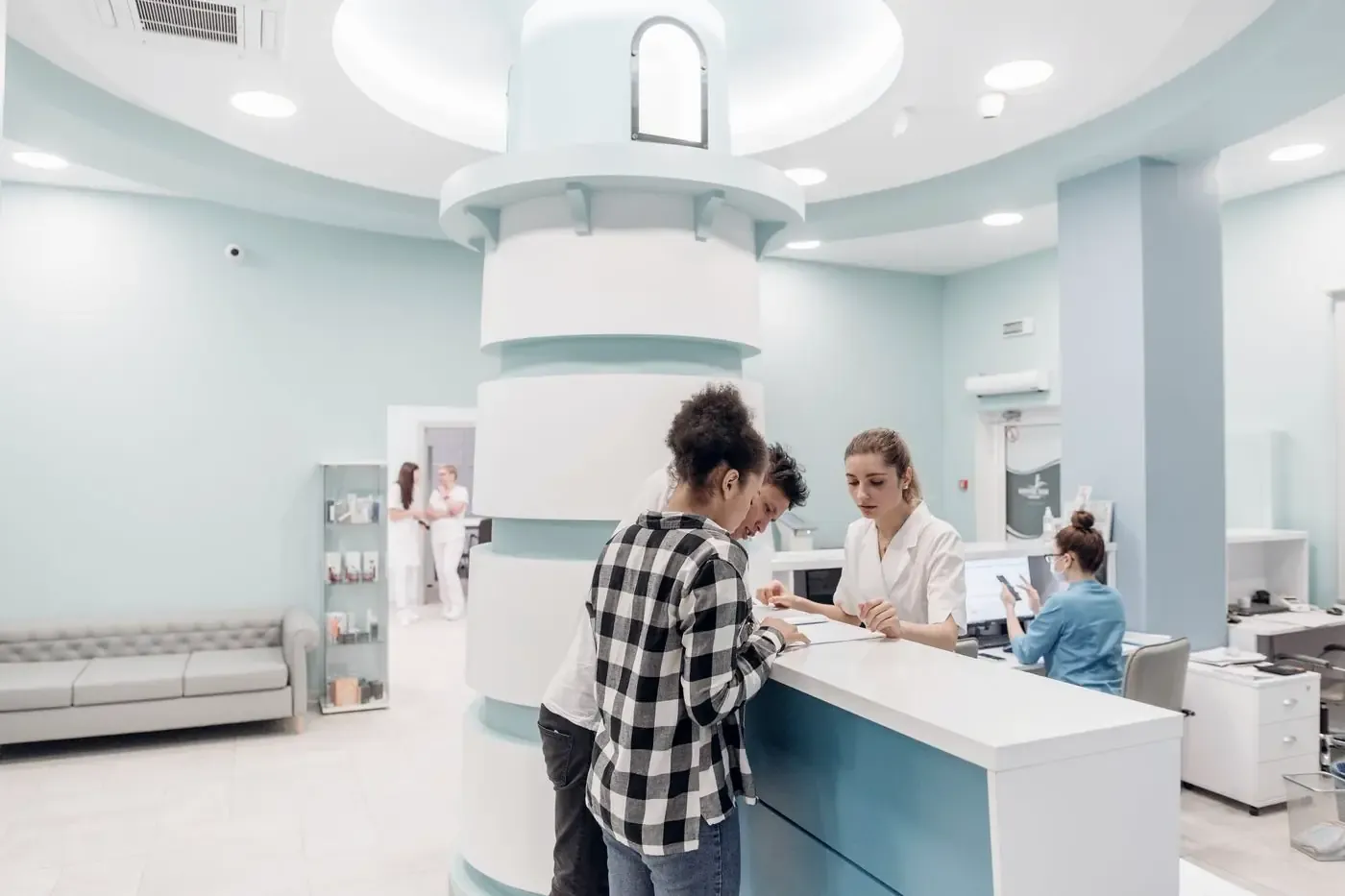 Patients registering at a clinic reception desk